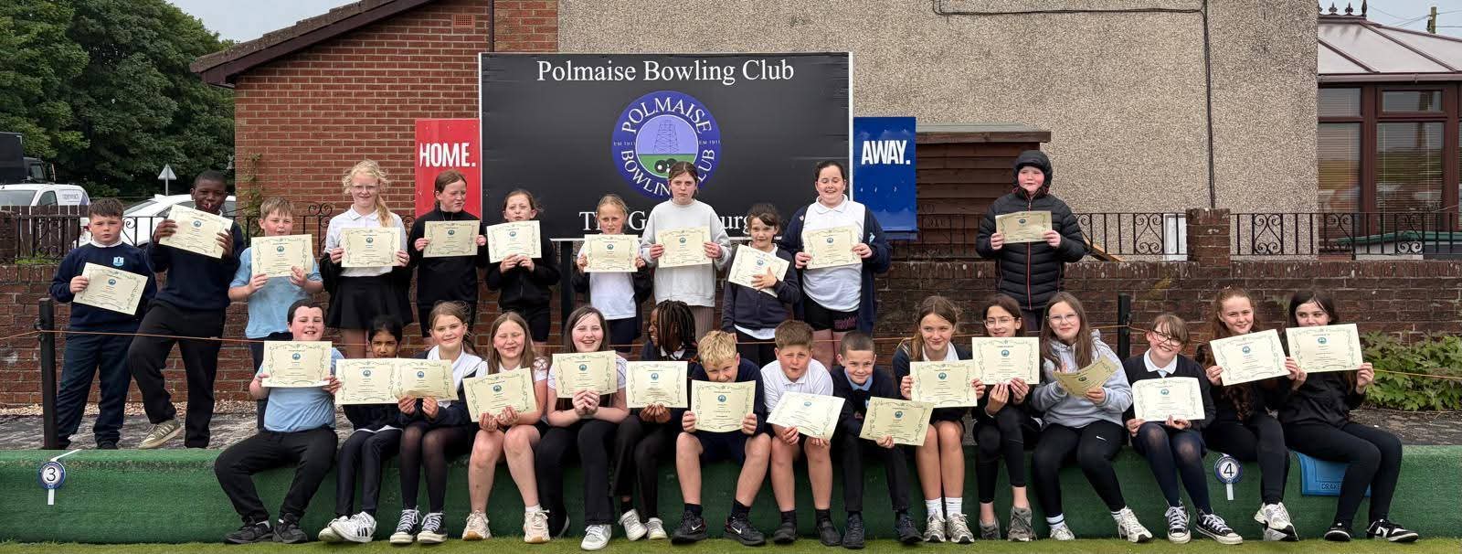 Fallin Primary School pupils proudly pose outside Polmaise Bowling Club holding their participation certificates